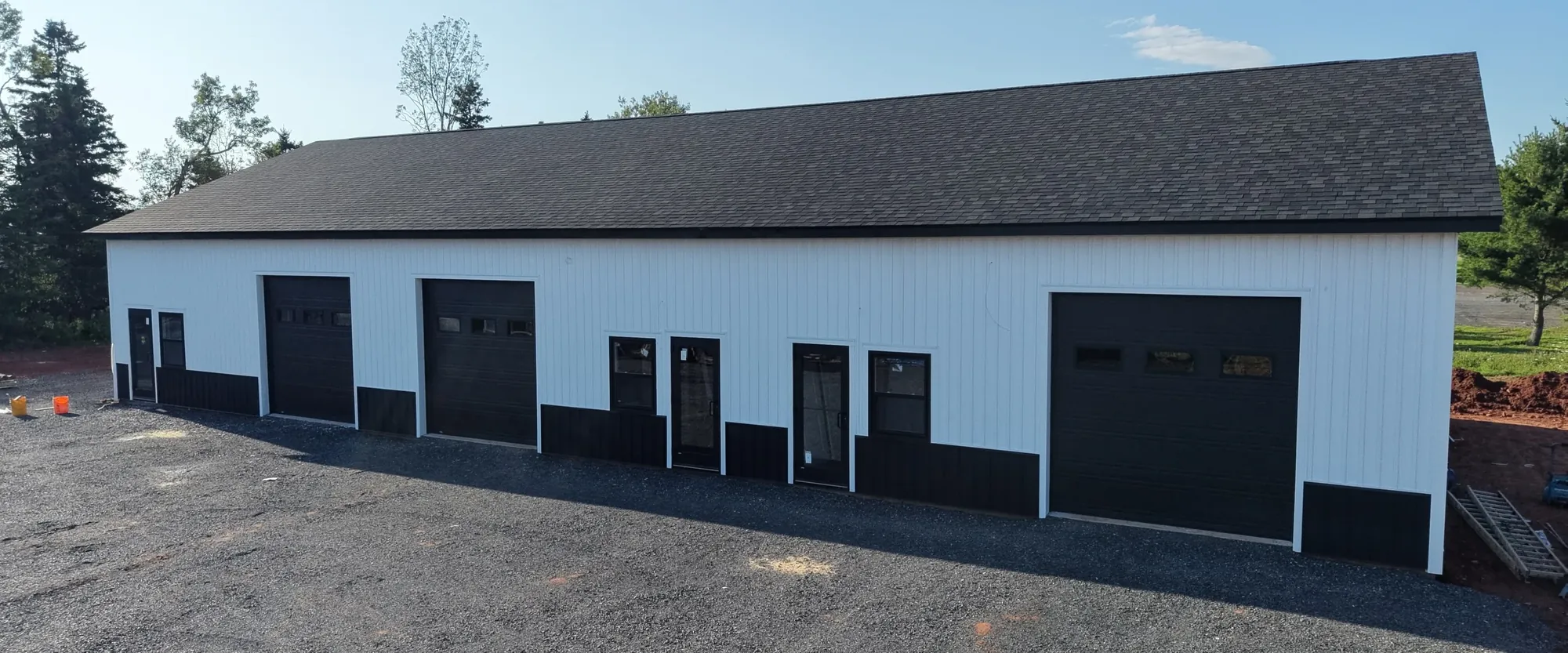 Pooles Corner Plaza from the air, a white commercial building with black bay doors